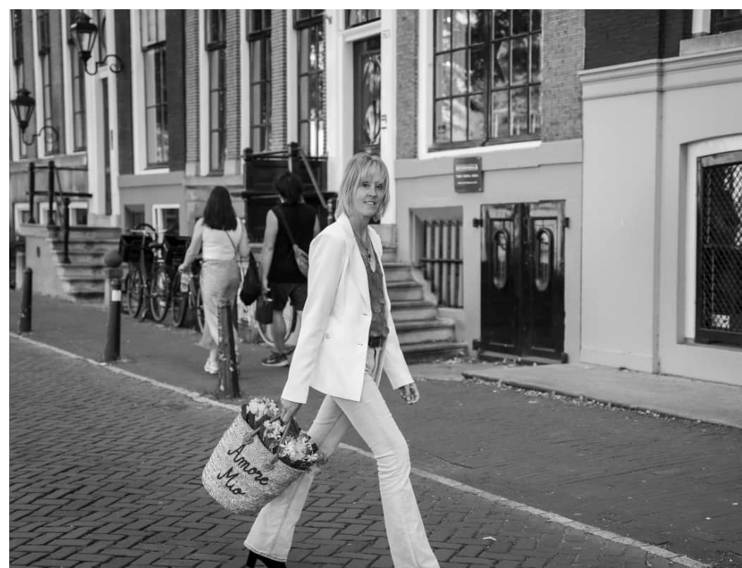 Nicole Stark walking along an Amsterdam street carrying flowers